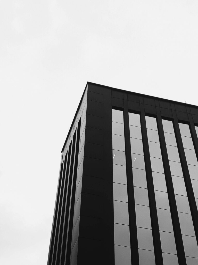 Black and white photo of a modern high-rise building with geometric lines and glass facade.